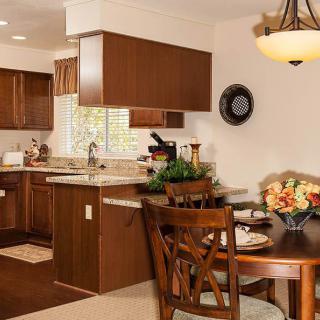 A cozy kitchen and dining area with wooden cabinets and a charming table setup.