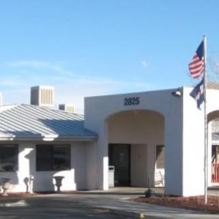 A small healthcare facility with flags displayed outside.