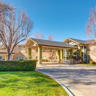 A modern building with a landscaped entrance on a sunny day.
