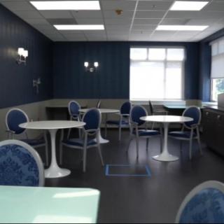 A modern dining area with blue and white decor, featuring multiple tables and chairs.