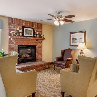 A cozy living room with a brick fireplace and comfortable seating.