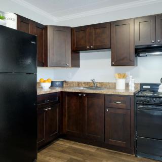Modern kitchen with dark cabinets and black appliances.