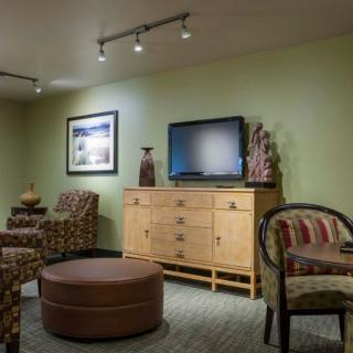 A cozy living room with comfortable seating, a flat-screen TV, and decorative accents.