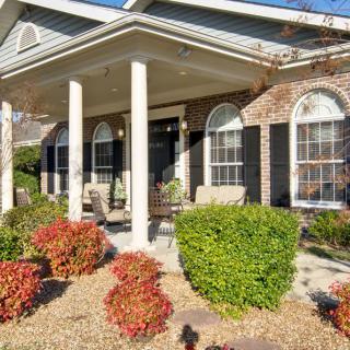 A well-maintained house with a covered porch and landscaped garden.