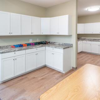A modern kitchen featuring white cabinets and granite countertops, designed for functionality and cleanliness.