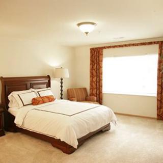 A cozy bedroom with classic wooden furniture and warm lighting.