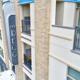 The exterior of The Deco, featuring modern architecture with balconies and signage.