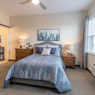 A cozy and well-decorated bedroom with a neatly made bed, nightstands, and framed artwork on the wall.