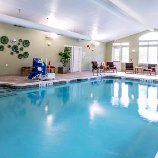 An inviting indoor swimming pool area with seating and wall decorations.