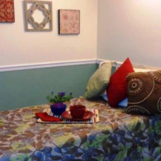 A cozy bedroom setup with decorative pillows and wall art.