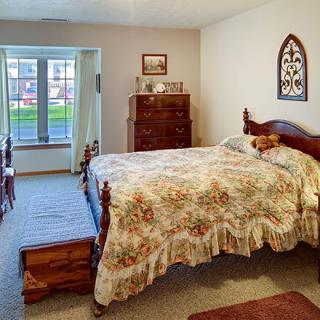 A cozy bedroom with wooden furniture and floral bedding.