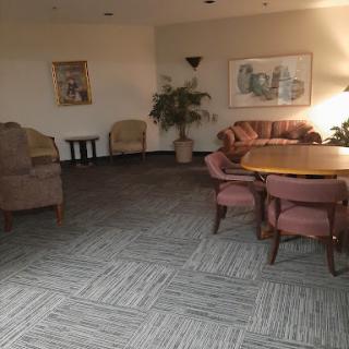 A cozy seating area featuring a round table, plush chairs, and decorative plants.
