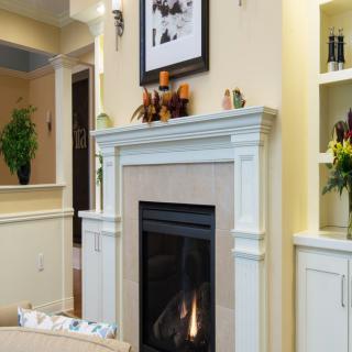 A cozy living room featuring a modern fireplace with elegant mantel decor.