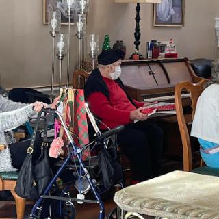 A serene moment indoors with elderly individuals enjoying each other's company.