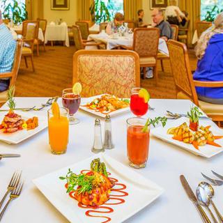 A beautifully set table with an array of dishes and drinks in a restaurant setting.