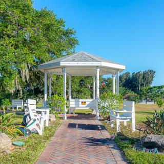 A scenic view of a gazebo surrounded by benches and lush greenery in a park.