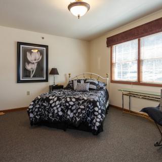 Cozy bedroom with floral bedding and wall art.