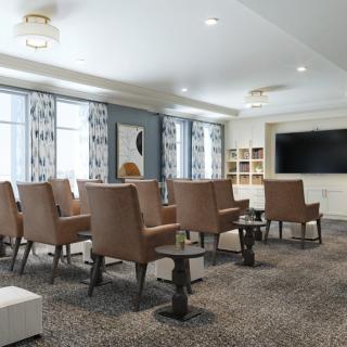 A modern conference room with comfortable seating and a large television.