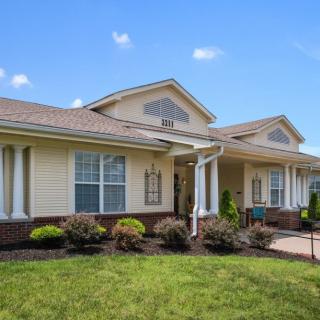A suburban house with a well-maintained front yard and clear blue sky.