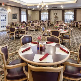 An elegant dining room with neatly arranged tables and chairs, set for a formal meal.
