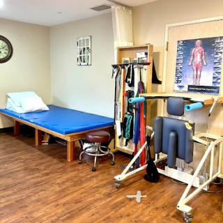 A functional physical therapy treatment room equipped with exercise tools and a therapeutic bed.