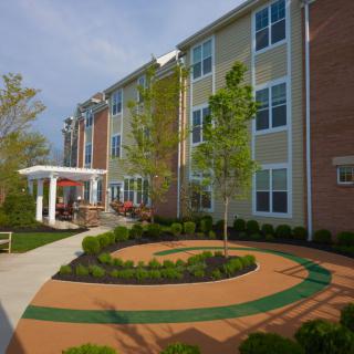An exterior view of a modern building with a landscaped garden and pathway.