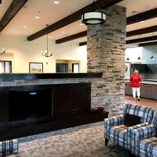 A spacious and modern lobby area featuring comfortable seating, a stone fireplace, and stylish lighting.