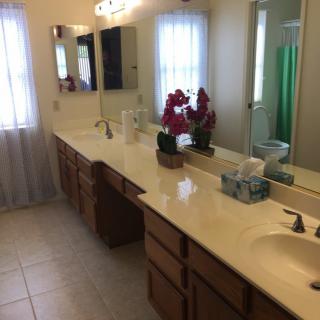 A spacious bathroom with a long countertop and dual sinks.