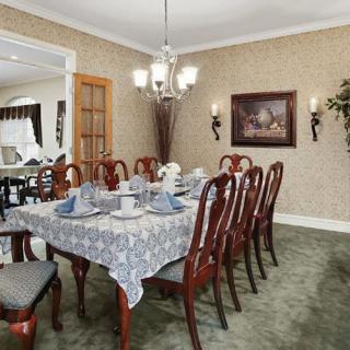 A formal dining room with a large table, elegant chairs, and a decorative chandelier.