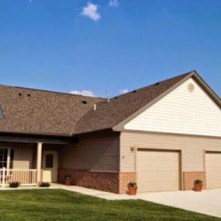 A suburban house with a two-car garage and a well-maintained lawn.