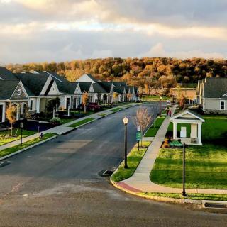 A peaceful suburban neighborhood at sunset with neatly lined houses and a quiet street.