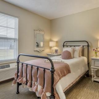 A cozy bedroom with a neatly made bed, soft lighting, and elegant decor.