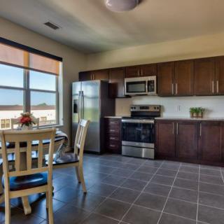 A modern kitchen with dark wood cabinets and a small dining area by the window.