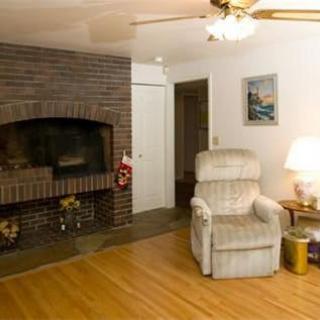 A cozy living room featuring a fireplace, armchair, and warm lighting.