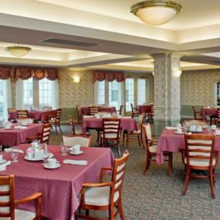 An empty dining room with tables set for a meal.
