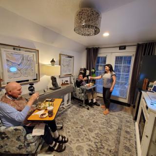 A group of people enjoying a conversation and meal in a cozy living room setting.