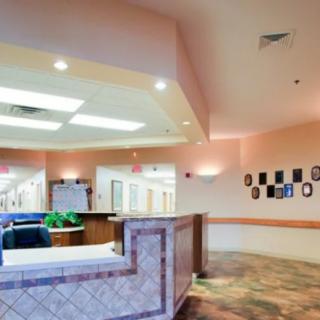 A spacious reception area with a front desk and hallway in an office setting.
