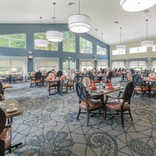 A spacious dining area with modern decor, featuring large windows and elegant lighting.