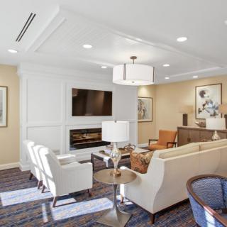 A modern living room with stylish furniture, a wall-mounted TV, and decorative artwork.