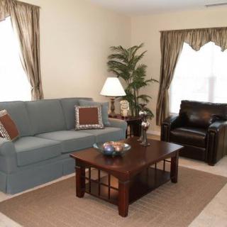 A cozy living room with a sofa, armchair, and coffee table.