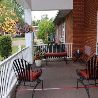 A cozy porch with comfortable seating and vibrant flowers, perfect for relaxation.