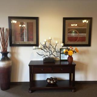 A stylish interior with a wooden console table, decorative vases, and framed artwork on the wall.