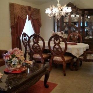 Elegant dining room with ornate furniture and a chandelier.