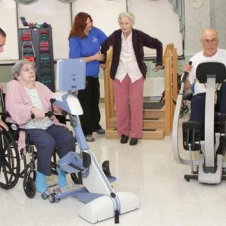 Elderly individuals participating in physical therapy exercises at a care facility.