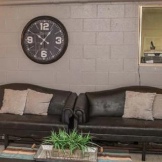 A cozy living room with two sofas, a large wall clock, and decorative elements.