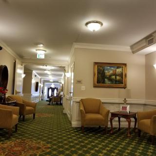 A hotel hallway featuring comfortable seating and framed artwork.