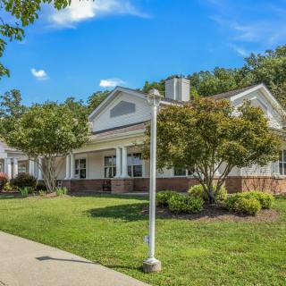 A suburban house with a well-maintained lawn and surroundings on a sunny day.