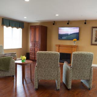 A cozy living room setup featuring comfortable armchairs, a television, and a warm ambiance.