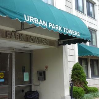 The entrance of Urban Park Towers, featuring a green canopy.