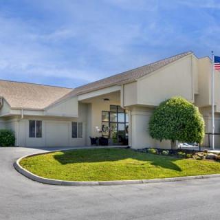 A commercial building with a landscaped entrance and a flagpole, likely a hotel.